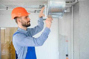 hvac arbeider installeren geleid pijp systeem voor ventilatie en lucht conditionering. kopiëren ruimte foto