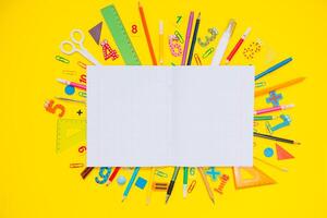 school- notitieboekje en schrijfbehoeften over- geel bureau. terug naar school- abstract achtergrond. school- apparatuur. verscheidenheid van school- benodigdheden. vlak leggen foto
