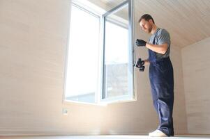 de arbeider installeren en controle venster in de huis. concept van nieuw modulair huizen. foto