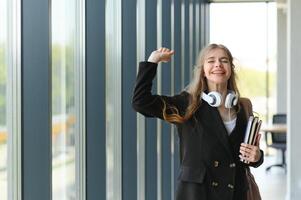 portret van een schoolmeisje Bij school. ze houdt boeken in haar handen. onderwijs concept. foto