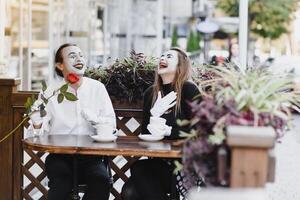 mimespelers in voorkant van Parijs cafe acteren Leuk vinden drinken thee of koffie. foto