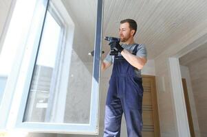 de arbeider installeren en controle venster in de huis. concept van nieuw modulair huizen. foto