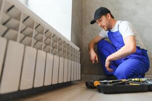 verwarming systeem installatie en onderhoud onderhoud. loodgieter installeren radiator. foto