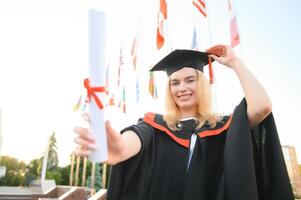 gelukkig Universiteit afstuderen meisje. de meisje is staand in de buurt de Universiteit tegen de achtergrond van de vlaggen van verschillend landen. de concept van Internationale onderwijs. foto