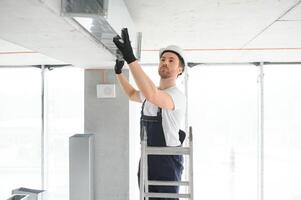 hvac Diensten - arbeider installeren geleid pijp systeem voor ventilatie en lucht conditioning foto