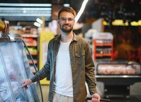 knap Mens boodschappen doen in een supermarkt foto