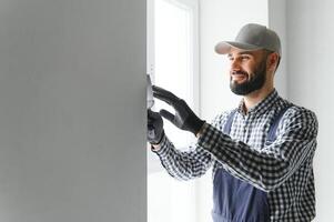 jong arbeider maken reparatie in kamer foto