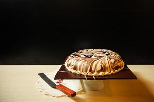 marmeren taart omvatten chocola, room, suiker met mes geserveerd Aan bord kant visie van cafe voedsel foto