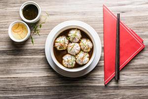 gepocheerd knoedel met saus en eetstokjes geïsoleerd Aan houten bord top visie Aan tafel Fast food foto