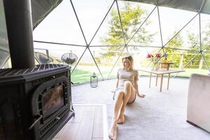 vrouw in interieur van modern luxe glamping tent kamp. eco ontwerp concept, natuurlijk foto