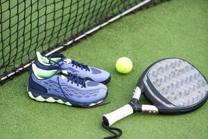 professioneel peddelen tennis racket met natuurlijk verlichting Aan blauw achtergrond. horizontaal sport thema poster, groet kaarten, koppen, website en app foto