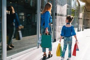 uitverkoop, consumentisme, geld en mensen concept - gelukkig jong vrouw met boodschappen doen Tassen en credit kaart in winkelcentrum. foto