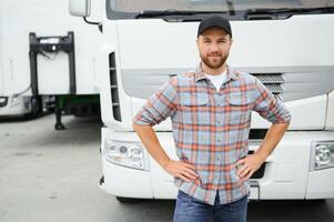 portret van jong Kaukasisch gebaard vrachtwagenchauffeur staand door zijn vrachtauto voertuig. vervoer onderhoud. vrachtauto bestuurder functie. foto