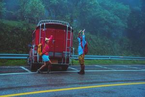 minnaar aziatische man en aziatische vrouwen reizen de natuur. natuurstudie in het regenwoud te midden van de regenachtige mist. reizen per minibus in chiangmai in thailand. foto