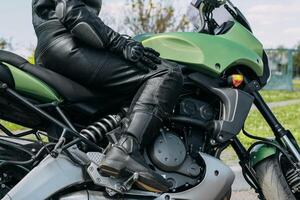 een meisje zit Aan een motorfiets in beschermend moto overall, veiligheid uitrusting foto