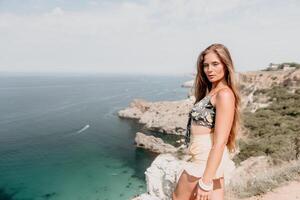 vrouw reizen zee. gelukkig toerist genieten nemen afbeelding buitenshuis voor herinneringen. vrouw reiziger looks Bij de rand van de klif Aan de zee baai van bergen, sharing reizen avontuur reis foto