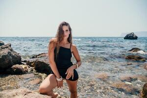 vrouw zomer reizen zee. gelukkig toerist in hoed genieten nemen afbeelding buitenshuis voor herinneringen. vrouw reiziger poseren Aan de strand Bij zee omringd door vulkanisch bergen, sharing reizen avontuur reis foto