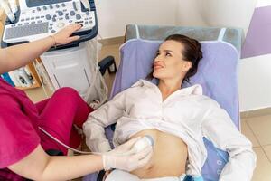 dokter het uitvoeren van een echografie scannen Aan zwanger vrouw. gelukkig emoties. modern kliniek. foto