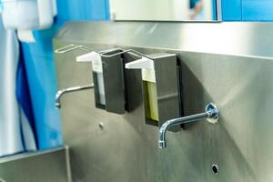 hand- wassen kamer in de ziekenhuis. steriel staal wastafel in modern chirurgie kamer. foto