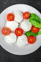 Mozzarella salade caprese tomaat, basilicum vers voedsel smakelijk aan het eten voorafje maaltijd voedsel tussendoortje foto