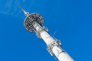 wit omroep toren tegen de blauw lucht foto