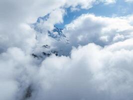 antenne visie van sneeuw gedekt Zwitsers Alpen pieken door wolken in de buurt verbier foto