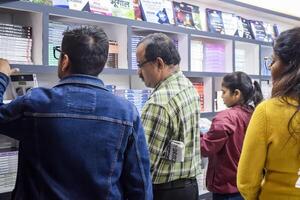 nieuw Delhi, Indië, februari 17 2024 - verscheidenheid van boeken Aan plank binnen een boekenstalletje Bij Delhi Internationale boek eerlijk, selectie van boeken Aan Scherm in jaar- boek eerlijk Bij bharat mandapam complex foto