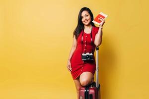 portret van reizen vrouw Holding een paspoort en vlieg ticket over- geel achtergrond. foto