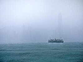 een veerboot vervoer in zwaar regen Bij Victoria haven, hong kong, kleurrijk water boot taxi, schip, beroemd veerboot voor dagelijks leven en toerisme, grijs regen mist in de achtergrond foto