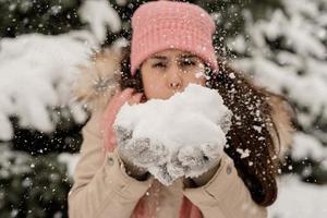 close-up van brunette vrouw die sneeuw blaast foto