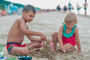 broer en zus maken zand kasteel Aan de strand in warm zomer dag.familie zomer vakantie concept.close omhoog. hoog kwaliteit foto