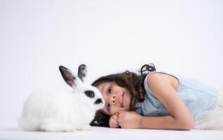 een weinig meisje kusjes haar geliefde pluizig konijn, de schoonheid van vriendschap tussen mensen en dieren foto