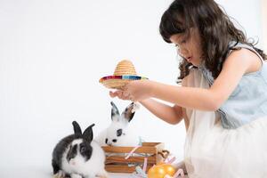 glimlachen weinig meisje en met hun geliefde pluizig konijn, presentatie van de schoonheid van vriendschap tussen mensen en dieren foto