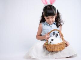 glimlachen weinig meisje en met hun geliefde pluizig konijn, presentatie van de schoonheid van vriendschap tussen mensen en dieren foto