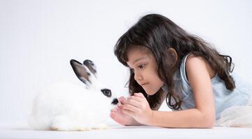 een weinig meisje kusjes haar geliefde pluizig konijn, de schoonheid van vriendschap tussen mensen en dieren foto