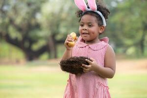 meisje genieten van buitenshuis activiteiten in de park inclusief een rennen naar verzamelen mooi Pasen eieren. foto