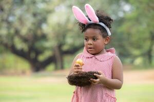 meisje genieten van buitenshuis activiteiten in de park inclusief een rennen naar verzamelen mooi Pasen eieren. foto