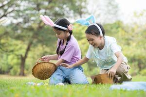 kinderen genieten van buitenshuis activiteiten in de park inclusief een rennen naar verzamelen mooi Pasen eieren. foto