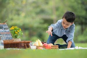 gelukkig familie genieten van een picknick in de park, met kinderen hebben pret zitten, omringd door natuur foto