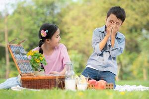 gelukkig familie genieten van een picknick in de park, kinderen zittend terug naar terug en lezing boeken. foto