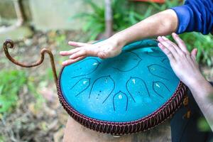 detailopname van handen spelen tong trommel, vadjraghanta of hand- pan foto