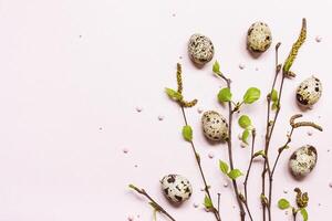 bloeiend jong twijgen en kwartel eieren Aan pastel roze achtergrond. gelukkig Pasen concept foto