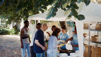 vrijwilligers portie vrij voedsel naar de behoeftig Bij een buitenshuis evenement. deze non-profit organisatie aanbiedingen humanitair steun en pleegt gemeenschap, helpen de hongerig en dakloos. antenne, handbediend. foto