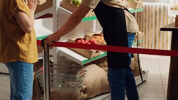 verkoper groet eerste klanten in nieuw geopend nul verspilling supermarkt, Verwijderen rood lintje. winkelier gastvrij klanten binnen milieuvriendelijk verantwoordelijk lokaal buurt op te slaan foto