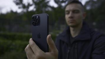 uk, Londen - september 15, 2023. Mens duurt afbeeldingen Aan iphone 15. actie. detailopname van appel logo Aan nieuw iphone 15 pro in handen van Mens. Mens schiet Aan nieuw iphone 15 pro met verbeterd het schieten kwaliteit foto