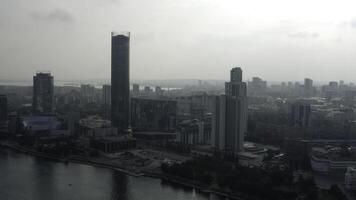 top visie van modern grijs stad in bewolkt het weer. voorraad filmmateriaal. grijs bewolkt stad met rivier- en mist. bewolkt dag hangende over- modern stad foto