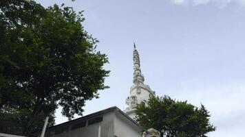 sri lanka, Kandy - juli 29, 2023. wit toren in sri lanka. actie. visie van hieronder Bij voet van wit toren van ambuluvava. wervelende wit toren met groen bomen in sri lanka foto