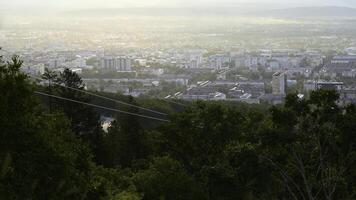 mooi visie van kabel auto met visie van stad- in zomer. klem. groen Woud Aan helling met in beweging kabel manieren Aan rand van dorp. mooi stad in vallei met kabel auto Aan zonnig zomer dag foto