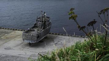 oud verlaten schip Aan kust. klem. verlaten houten schip staat Aan dijk platform. geborgen oud verlaten schip Aan kust foto