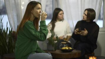 studenten praten en kom tot rust in knus cafe. media. mooi jong vrouw is drinken thee Aan achtergrond van pratend paar. studenten kom tot rust en drinken thee in college cafe foto